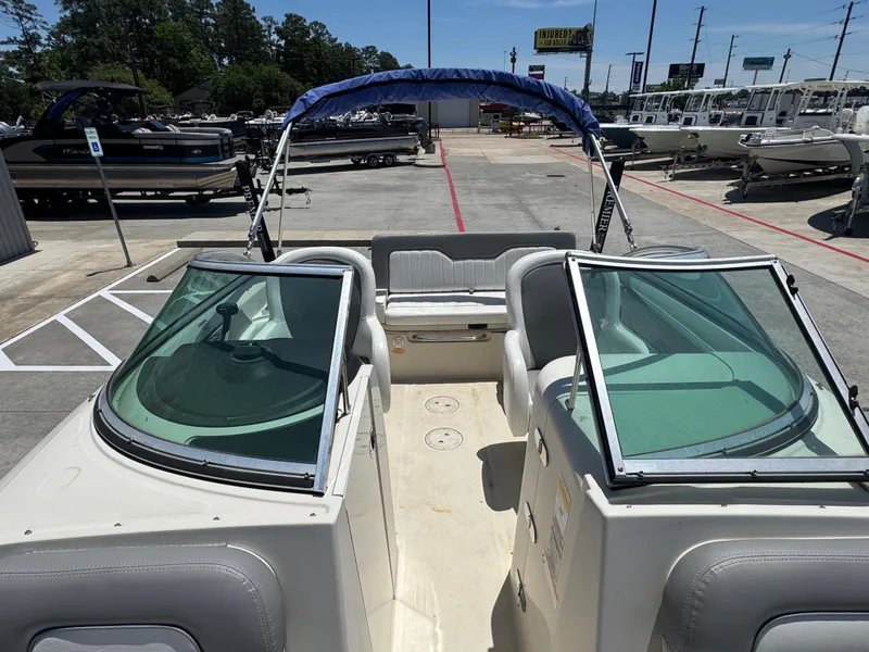 Slide: The Image of 2010 Sea Ray 220 Sundeck boat with open cockpit and seating, displayed outdoors. - 24