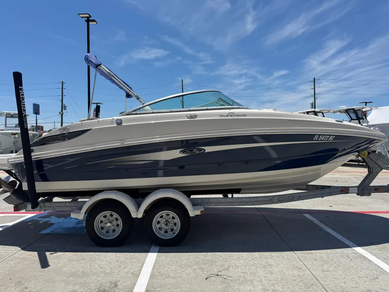 Slide: The Image of 2010 Sea Ray 220 Sundeck boat on trailer under clear blue sky. - 3