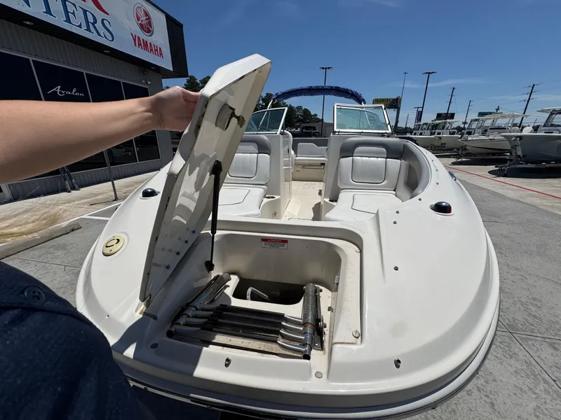 Slide: The Image of 2010 Sea Ray 220 Sundeck boat with open storage compartment, displayed outdoors. - 9