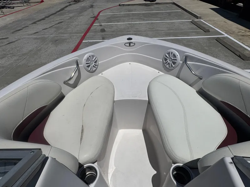 Slide: The Image of 2015 TAHOE WRMG Q7I boat interior with white seating and speakers in a parking lot. - 13