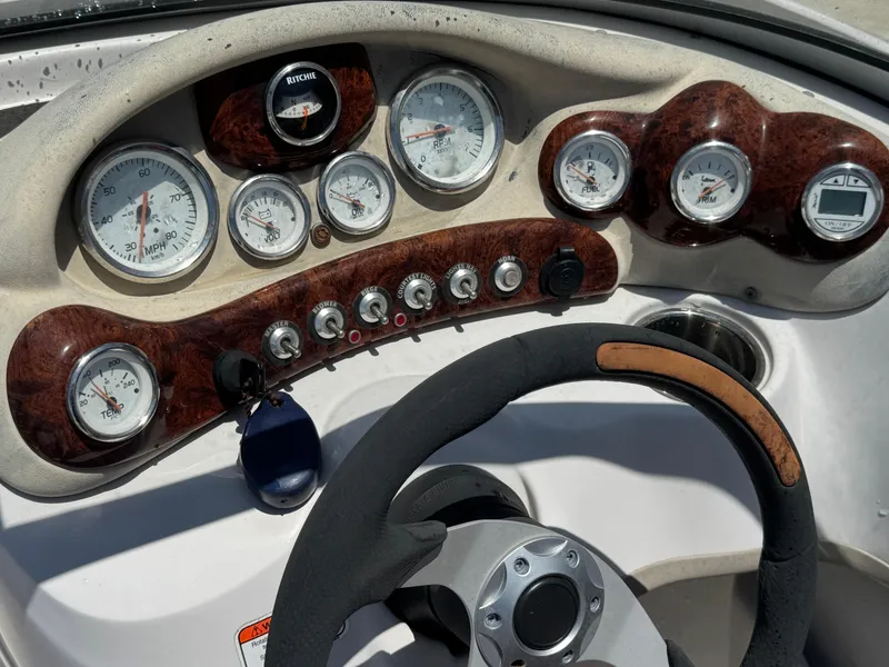 Slide: The Image of Dashboard of a 2015 TAHOE WRMG Q7I boat with gauges and steering wheel. - 18