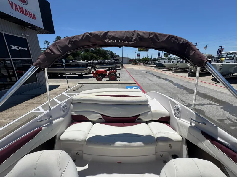 Slide: The Image of Interior view of a 2015 TAHOE Q7I boat at a dealership, featuring white seating. - 21