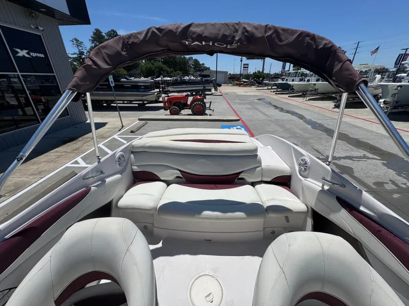 Slide: The Image of 2015 TAHOE Q7I boat interior with white seating and canopy, parked at a dealership. - 22