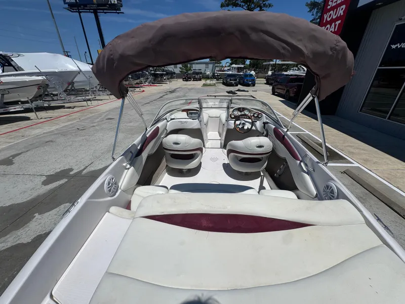 Slide: The Image of 2015 TAHOE Q7I boat with canopy, white and maroon interior, parked outdoors. - 24