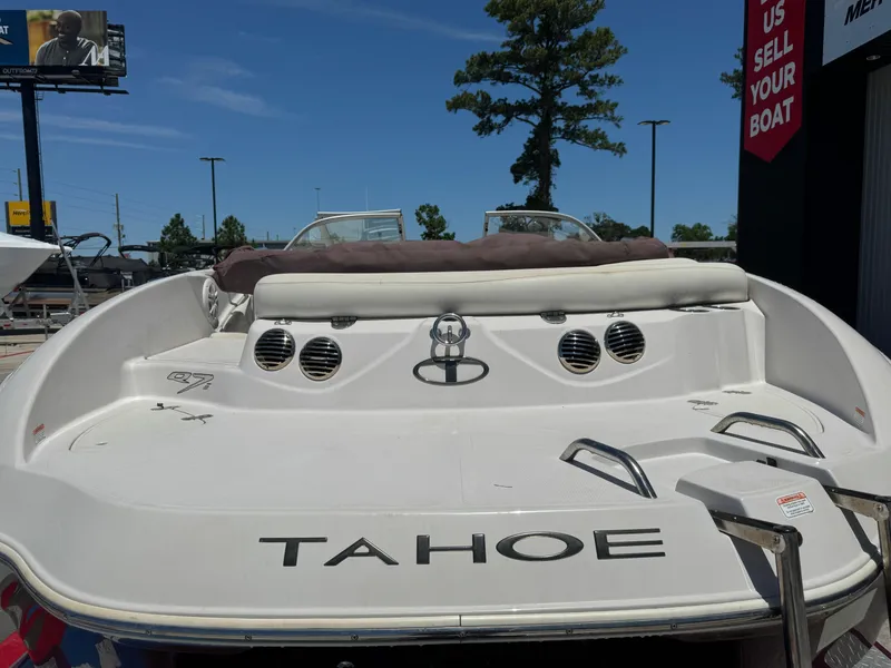 Slide: The Image of 2015 TAHOE Q7I boat rear view with seating and ladder under clear blue sky. - 9