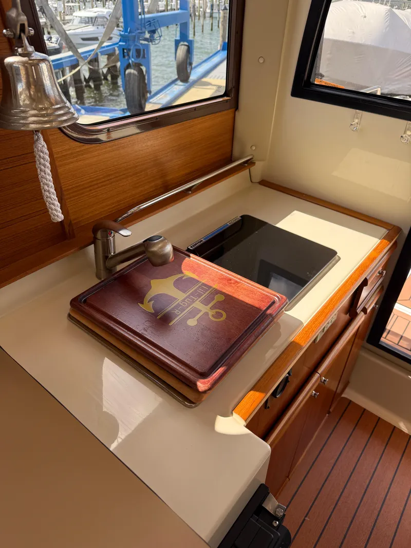 Slide: The Image of 2023 Ranger Tugs R-25 interior with sink, stove, and nautical decor. - 11