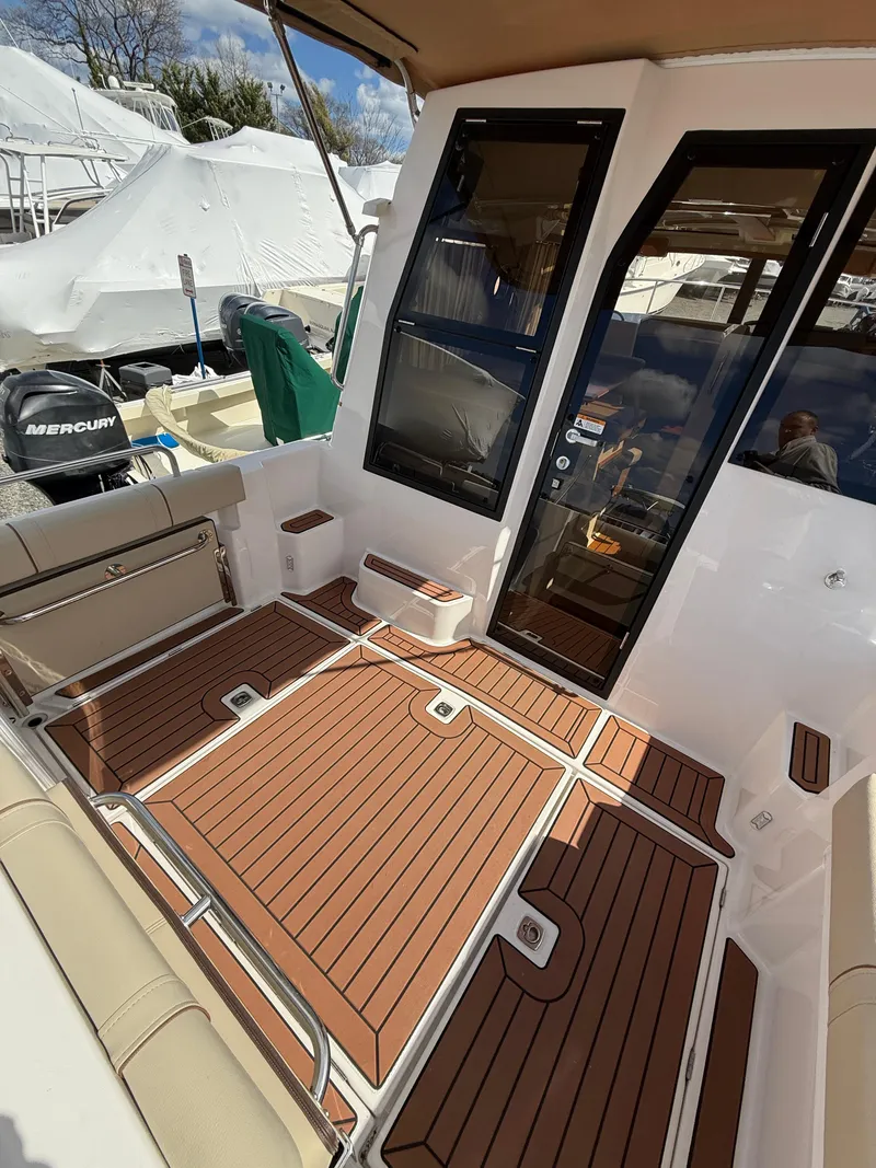 Slide: The Image of 2023 Ranger Tugs R-25 boat interior with teak flooring and seating area. - 25