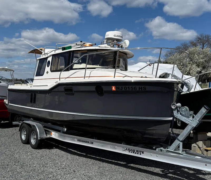 Slide: The Image of 2023 Ranger Tugs R-25 boat on trailer under a cloudy sky. - 3