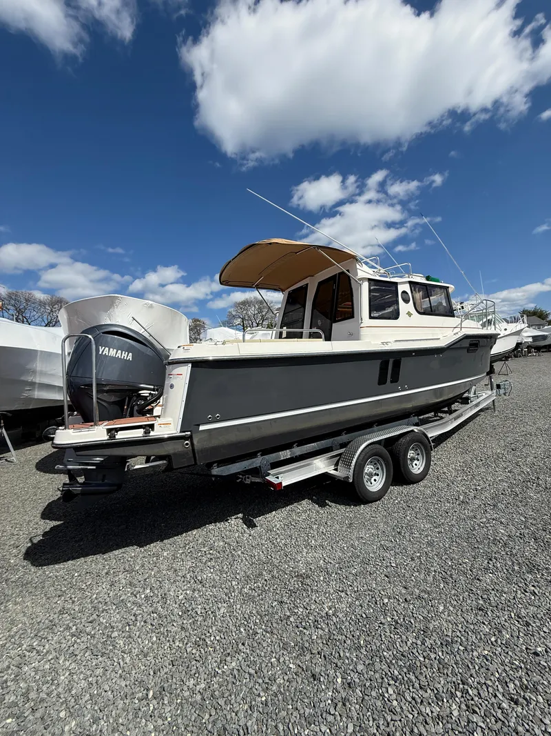 Slide: The Image of 2023 Ranger Tugs R-25 boat on trailer under blue sky with clouds. - 6