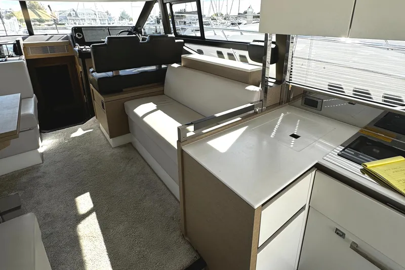 Slide: The Image of Interior of 2019 Prestige 460 Fly Bridge yacht, featuring modern seating and kitchen area. - 14