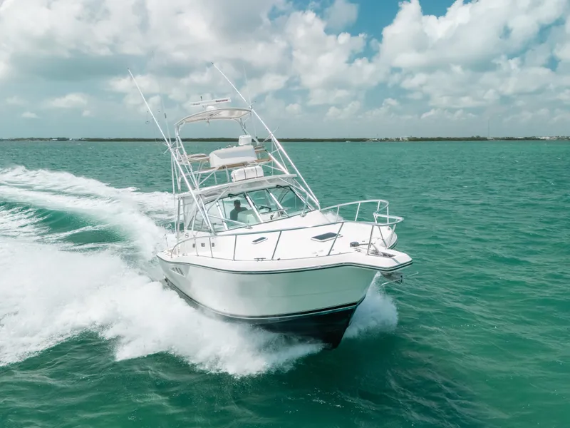 Slide: The Image of 2007 Rampage 38 Express boat cruising on turquoise waters under a partly cloudy sky. - 1