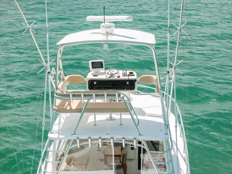 Slide: The Image of 2007 Rampage 38 Express boat on turquoise water, featuring upper deck controls. - 10