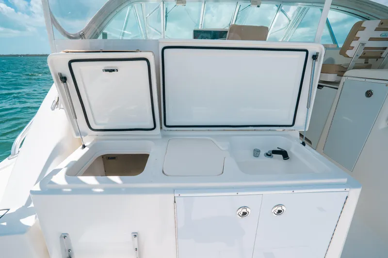 Slide: The Image of 2007 Rampage 38 Express boat with open storage compartments and sink on deck. - 25