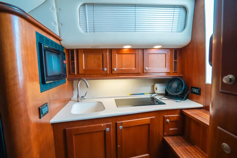Slide: The Image of 2007 Rampage 38 Express yacht kitchen with wooden cabinets and modern appliances. - 29