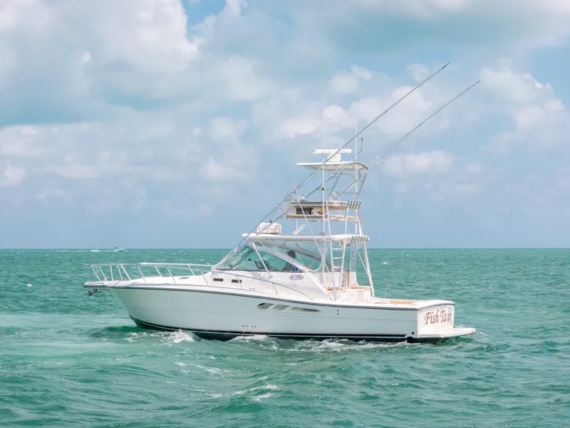 Slide: The Image of 2007 Rampage 38 Express boat cruising on turquoise ocean under cloudy sky. - 39
