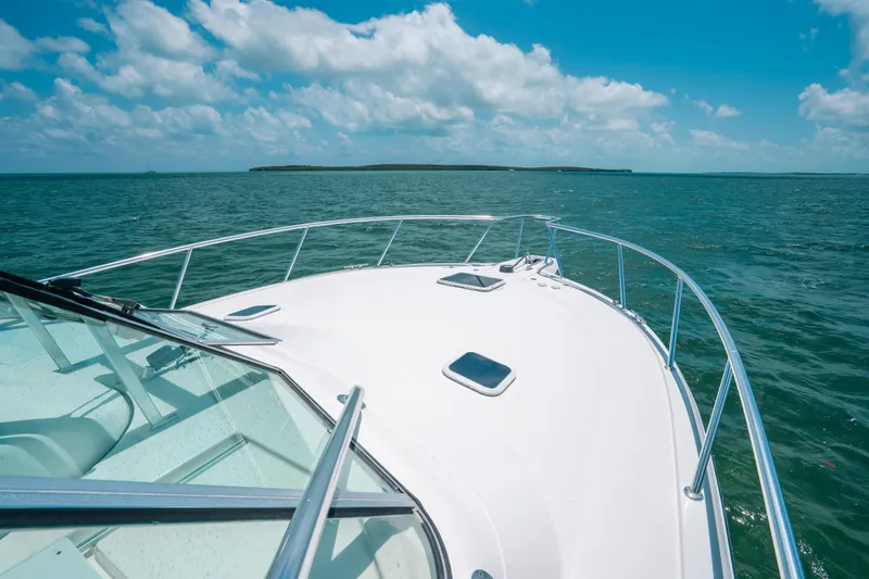 Slide: The Image of 2007 Rampage 38 Express boat cruising on open water under a clear blue sky. - 42