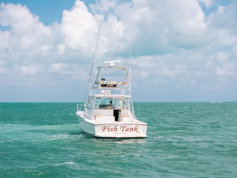 Slide: The Image of 2007 Rampage 38 Express boat named "Fish Tank" on open sea under cloudy sky. - 46