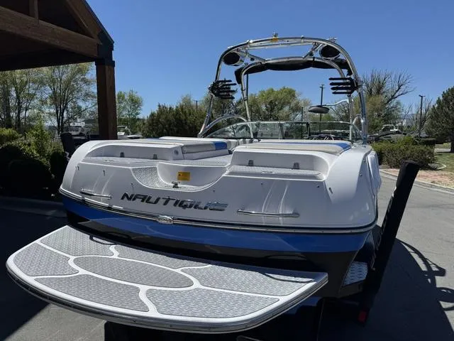 Slide: The Image of 2008 Nautique 230 TEAM EDITION boat with wakeboard tower, parked outdoors. - 6