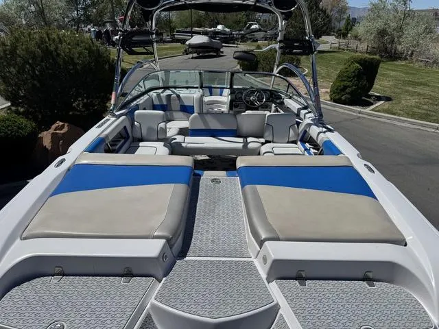 Slide: The Image of 2008 Nautique 230 TEAM EDITION boat with blue and gray seating, parked outdoors. - 8