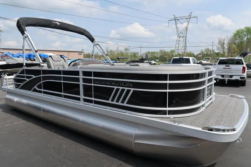 Slide: The Image of 2025 Bennington L Swingback 23 LSB pontoon boat in a parking lot. - 16