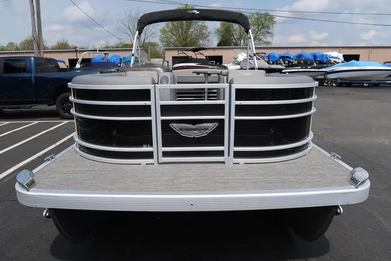 Slide: The Image of 2025 Bennington L Swingback 23 LSB pontoon boat, front view in a parking lot. - 2