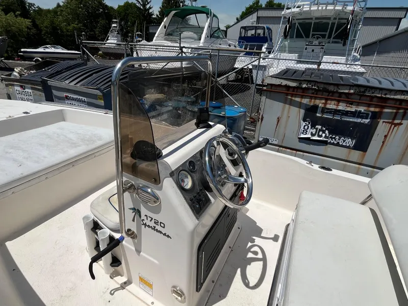 Slide: The Image of 2006 Key West 1720 Center Console boat with steering wheel and controls, docked in marina. - 2