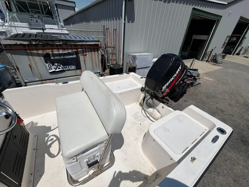 Slide: The Image of 2006 Key West 1720 Center Console boat with Mercury outboard motor, docked near a warehouse. - 5