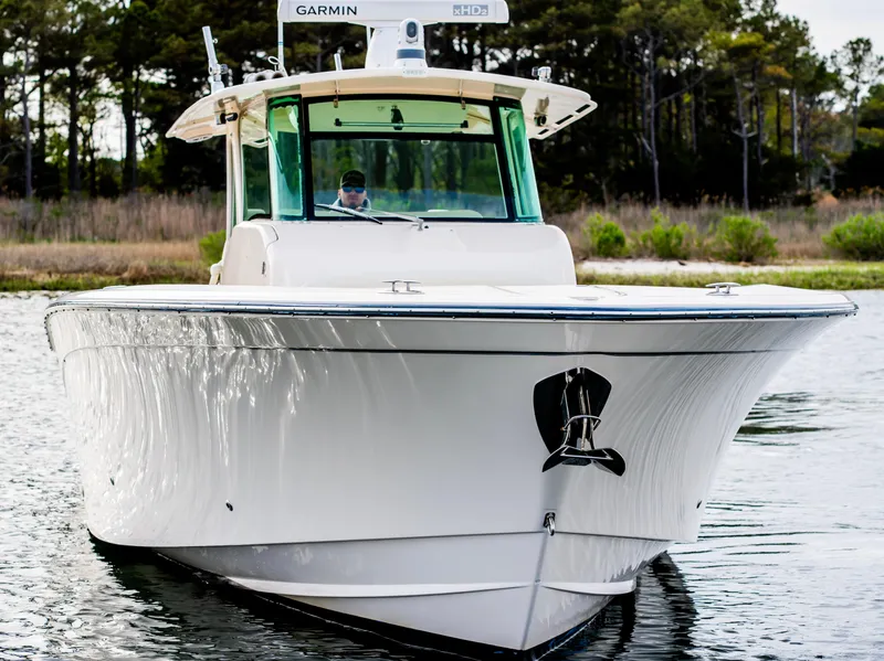 Slide: The Image of 2015 Grady-White Canyon 376 boat on water, front view with trees in background. - 11