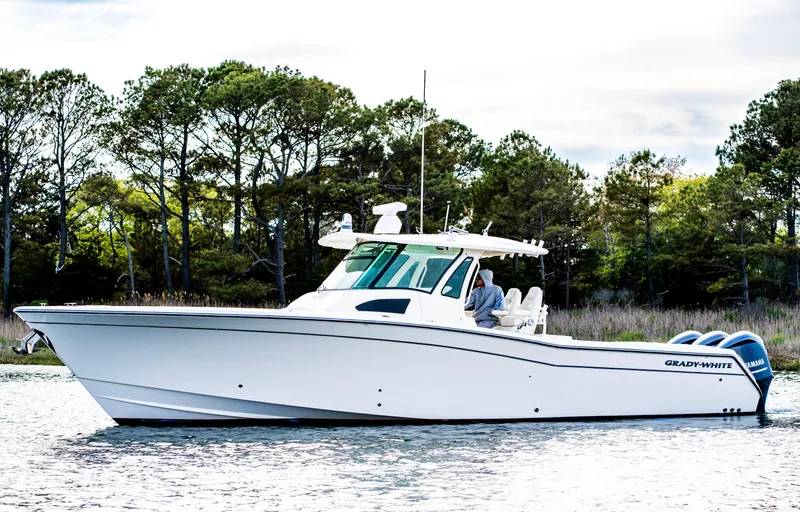 Slide: The Image of 2015 Grady-White Canyon 376 boat on water, surrounded by trees. - 4