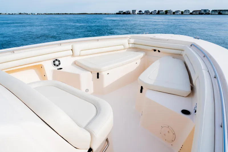 Slide: The Image of 2015 Grady-White Canyon 376 boat interior with cushioned seating, on calm blue water. - 6