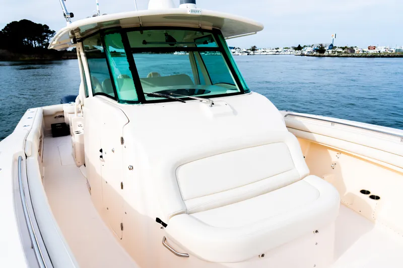Slide: The Image of 2015 Grady-White Canyon 376 boat on calm water, showcasing spacious deck and cabin. - 7