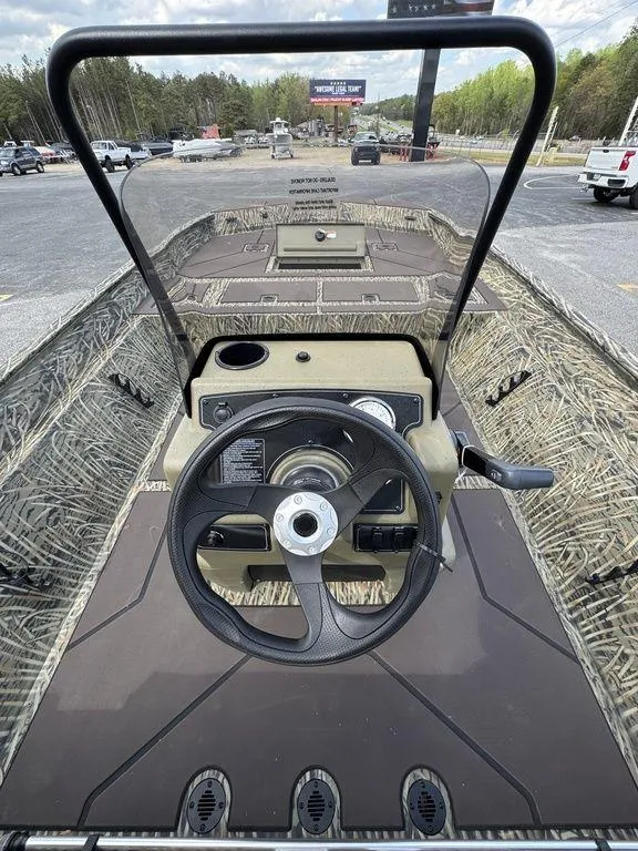Slide: The Image of 2025 Tracker GRIZZLY® 2072 CC boat interior with steering wheel and camouflage design. - 15
