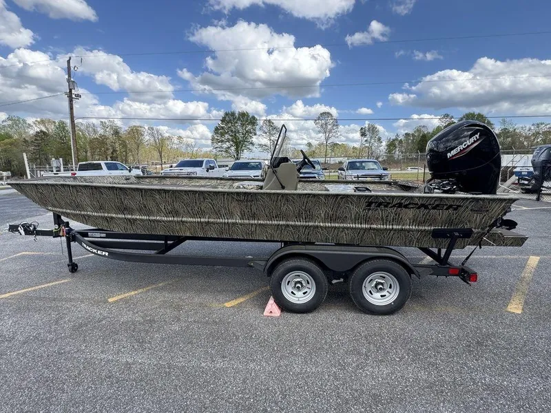 Slide: The Image of 2025 Tracker GRIZZLY® 2072 CC boat on trailer, parked outdoors under a cloudy sky. - 4