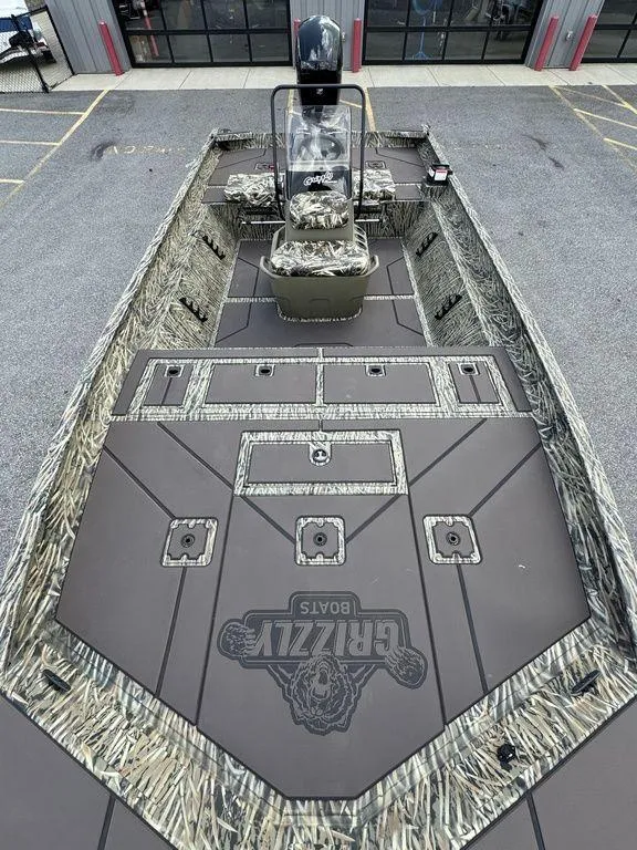 Slide: The Image of 2025 Tracker GRIZZLY® 2072 CC boat with camouflage design, parked outdoors. - 9