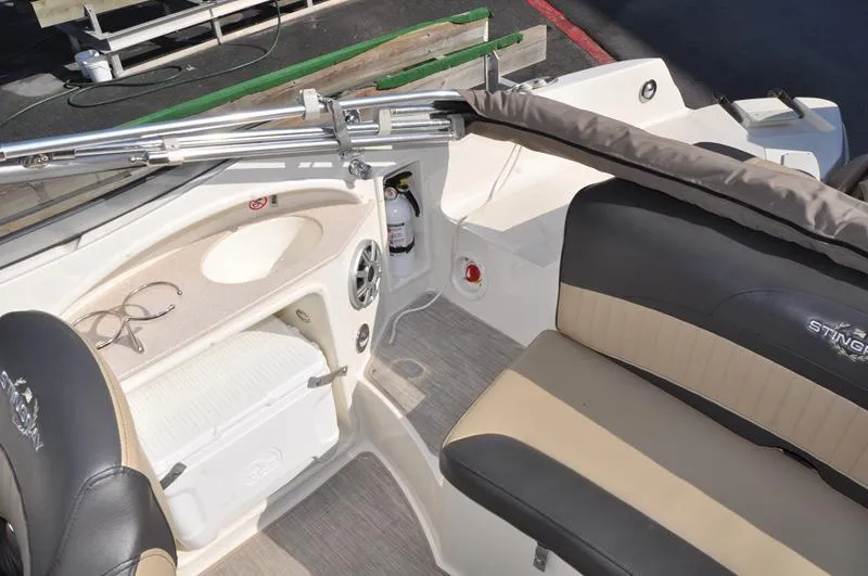 Slide: The Image of 2018 Stingray 214 LR boat interior with seating and storage compartments. - 11