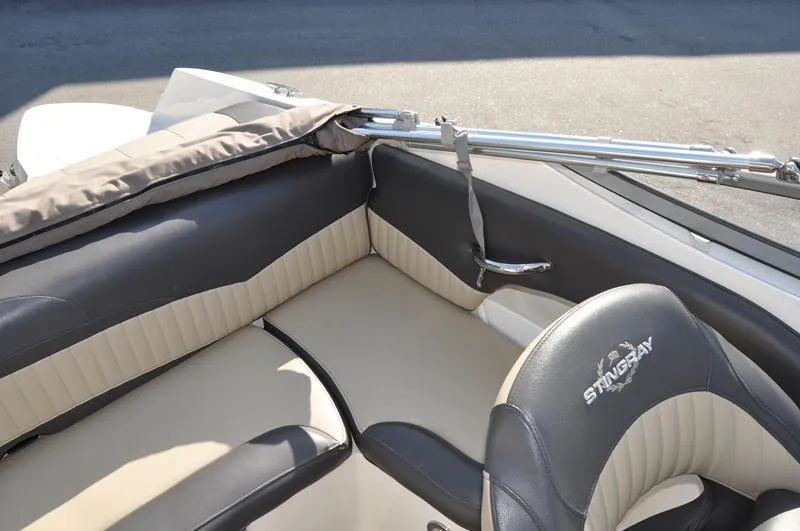 Slide: The Image of 2018 Stingray 214 LR boat interior with beige and black seating. - 12
