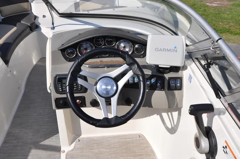 Slide: The Image of 2018 Stingray 214 LR boat dashboard with Garmin navigation system and steering wheel. - 14