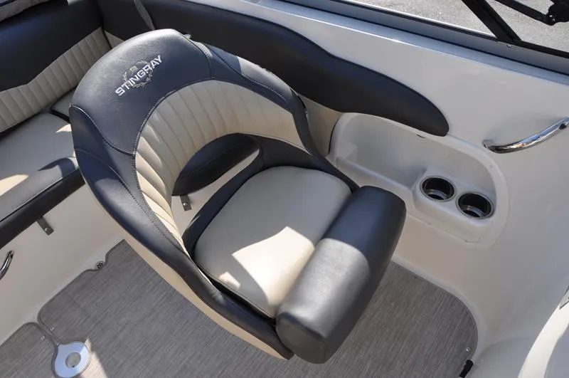 Slide: The Image of 2018 Stingray 214 LR boat interior with cushioned seating and cup holders. - 15