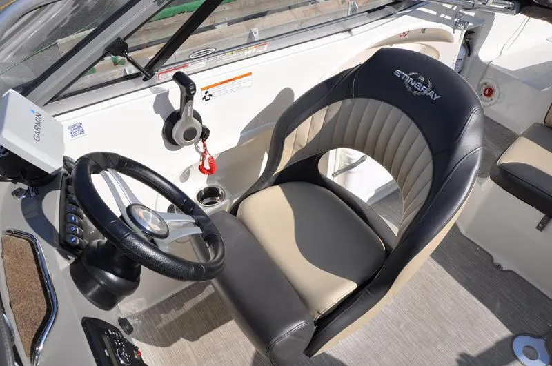 Slide: The Image of 2018 Stingray 214 LR boat cockpit with steering wheel and comfortable seating. - 16