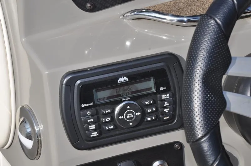 Slide: The Image of 2018 Stingray 214 LR boat dashboard with audio system and steering wheel. - 18