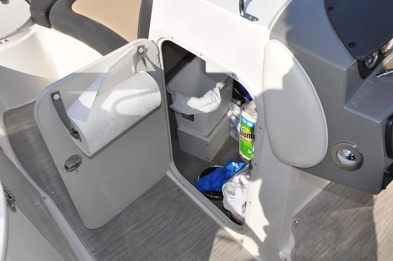 Slide: The Image of 2018 Stingray 214 LR boat interior storage compartment with cleaning supplies and accessories. - 20