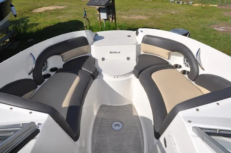 Slide: The Image of 2018 Stingray 214 LR boat interior with cushioned seating and open deck layout. - 21