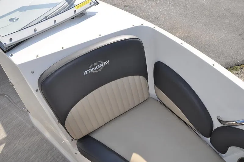 Slide: The Image of 2018 Stingray 214 LR boat seat with logo, featuring black and beige upholstery. - 24