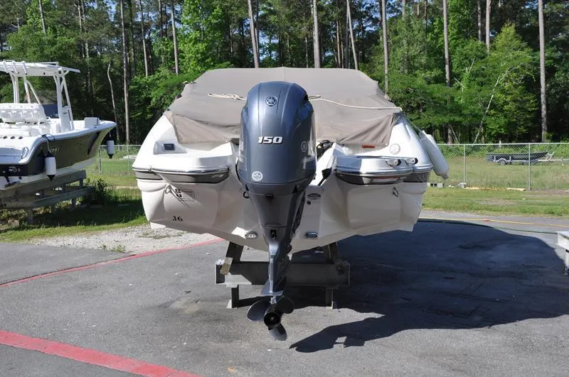 Slide: The Image of 2018 Stingray 214 LR boat with 150 HP engine, covered and parked outdoors. - 3