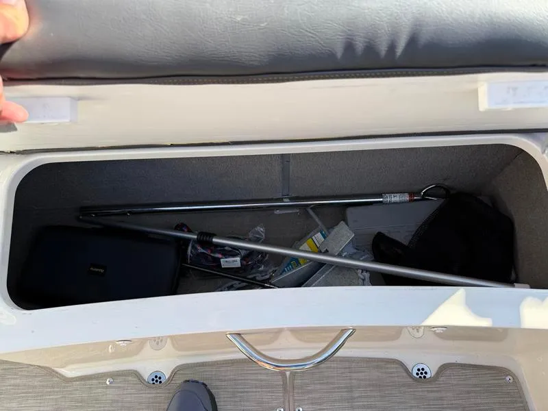 Slide: The Image of Storage compartment of a 2018 Stingray 214 LR boat with various items inside. - 32