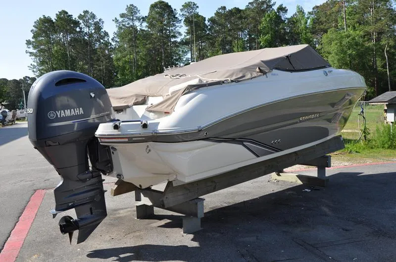 Slide: The Image of 2018 Stingray 214 LR boat with Yamaha outboard motor, covered and parked outdoors. - 4