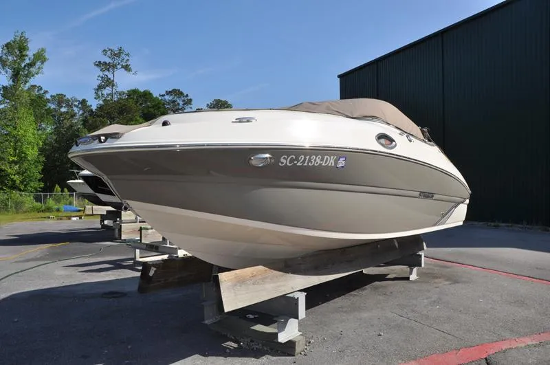 Slide: The Image of 2018 Stingray 214 LR boat on display, covered and elevated, outdoors. - 8