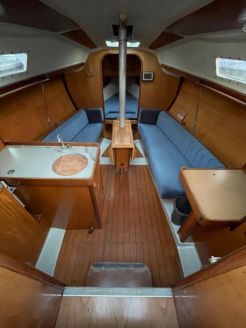 Slide: The Image of Interior of 1990 Beneteau First 285 sailboat with wood finish and blue seating. - 5