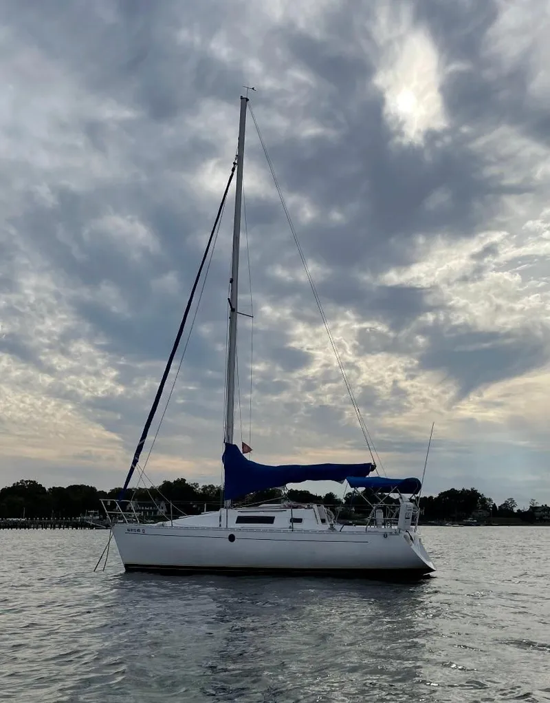 Slide: The Image of 1990 Beneteau First 285 sailboat on calm water under cloudy sky. - 6