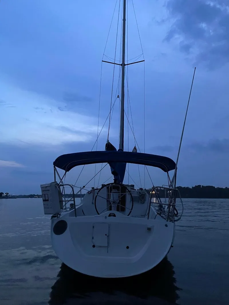 Slide: The Image of Sailboat Beneteau First 285, 1990 model, docked at dusk on calm waters. - 7